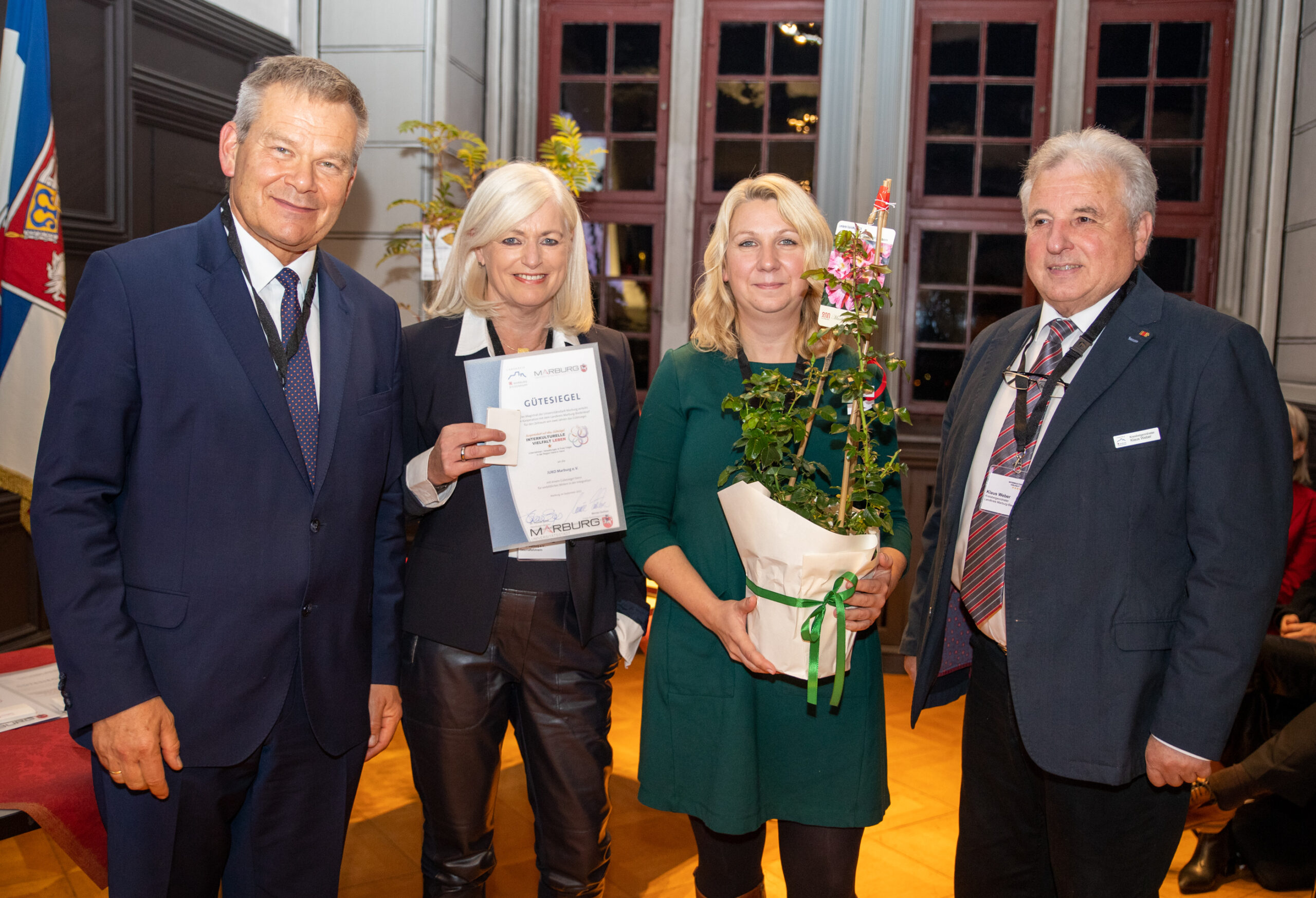 Oberbürgermeister Dr. Thomas Spies und der Vertreter des Landkreises, Herr Weber, überreichen das Gütesiegel an Maria Flohrschütz und Annika Haas.
